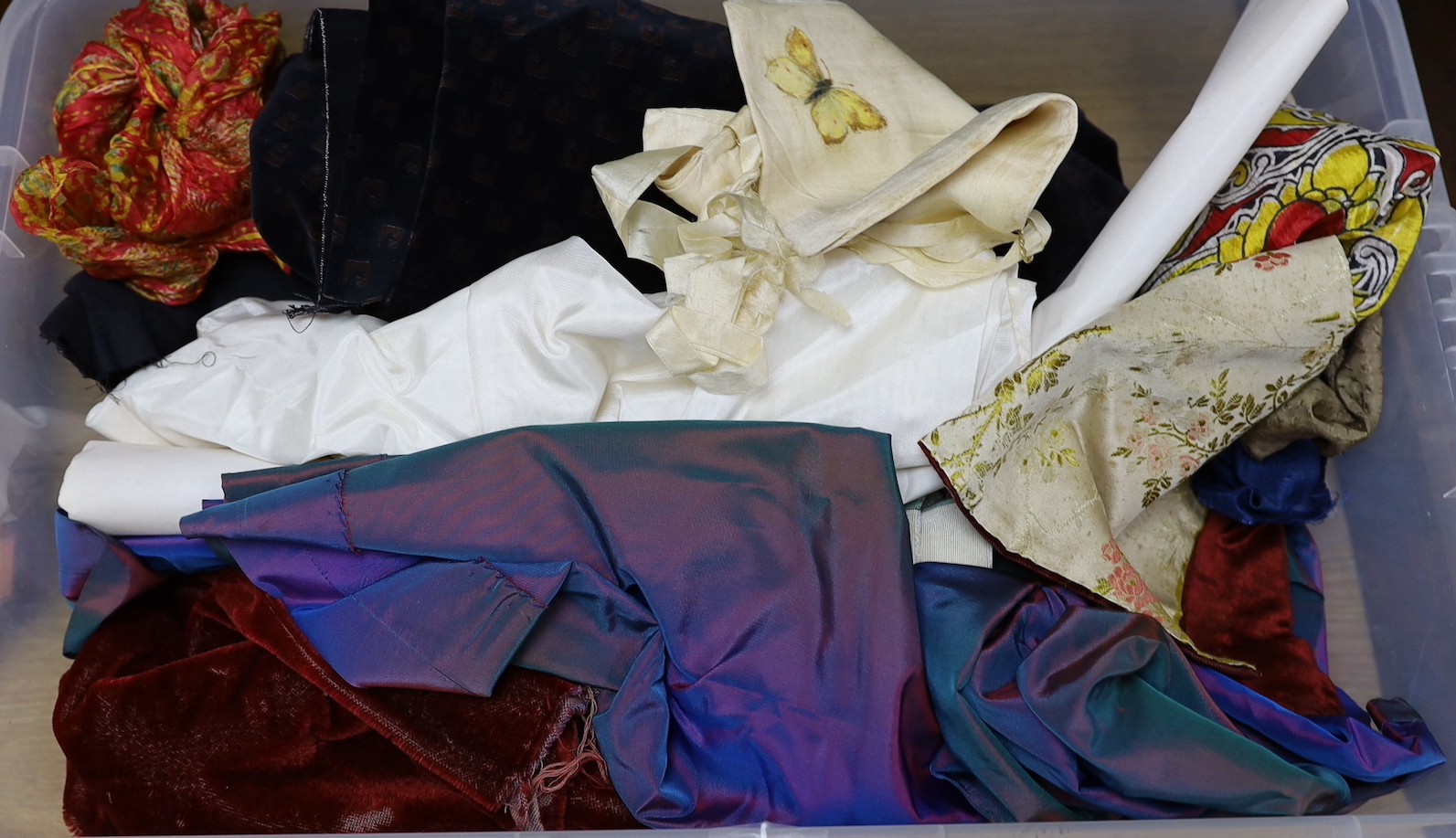 A collection of fabrics, silks, velvets and a shot silk taffeta skirt, ribbons and 19th century samples cut velvets